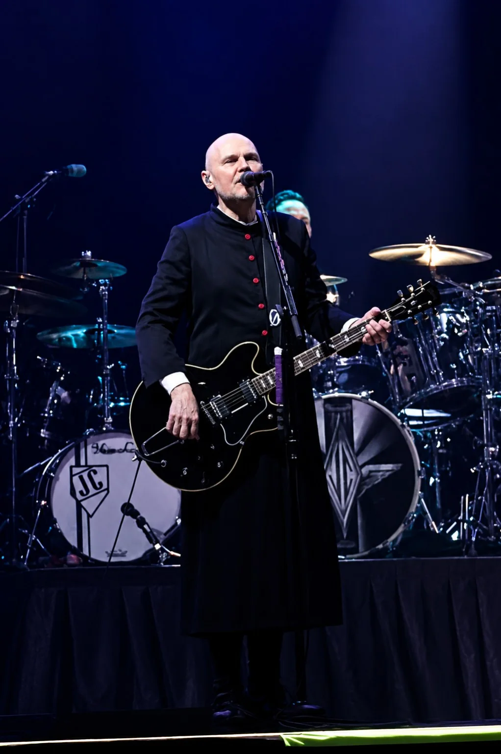 Guitarist performing under blue stage lighting